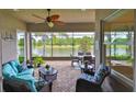 Relaxing screened-in patio with comfortable seating and peaceful water views of the lake at 4830 Grand Banks Dr, Wimauma, FL 33598