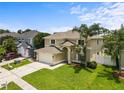 Two-story home with lush green lawn, palm trees, and a two-car attached garage at 4852 Trinidad Dr, Land O Lakes, FL 34639