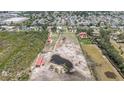 Wide aerial view of the property showing its large lot, barns, pond, and surrounding neighborhood at 5012 Troydale Rd, Tampa, FL 33615