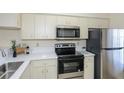Well-lit kitchen featuring stainless steel appliances, light cabinetry, and sleek quartz countertops at 6334 Spring Flower Dr # 24, New Port Richey, FL 34653