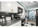 Well-equipped kitchen with black and white tile floors, white cabinetry and modern appliances at 634 6Th N St, St Petersburg, FL 33701