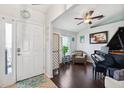 Inviting entryway featuring a white front door, tile flooring, and hardwood floors leading to a living area with a piano at 6724 Clair Shore Dr, Apollo Beach, FL 33572