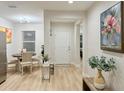 Inviting entryway featuring modern decor, light wood floors, and access to dining and living areas at 6977 Hawksbury St, Englewood, FL 34224