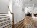 Bright hallway with wooden floors, a staircase, and a view into a home office and living room at 718 W Kentucky Ave, Tampa, FL 33603