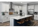 Modern kitchen featuring white cabinets, stainless steel appliances, a central island with seating, and quartz countertops at 718 W Kentucky Ave, Tampa, FL 33603