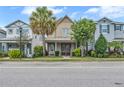 Charming two-story home featuring a covered porch with swing and manicured landscaping at 7238 Milestone Dr, Apollo Beach, FL 33572