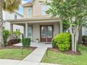 Inviting front porch with double doors, seating, and lush landscaping at 7238 Milestone Dr, Apollo Beach, FL 33572
