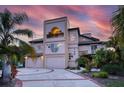 Elegant multi-story home showcasing a unique architectural design with a circular driveway at 812 Point Seaside Dr, Crystal Beach, FL 34681