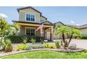 Charming home featuring an American flag, lush landscaping, and brick driveway at 10313 Scarlet Chase Dr, Riverview, FL 33569