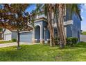 Charming two-story home with two car garage, lush lawn and mature tropical trees at 10808 Whitecap Dr, Riverview, FL 33579