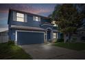 Inviting two-story home featuring an attached two-car garage, manicured lawn, and mature trees at 10808 Whitecap Dr, Riverview, FL 33579