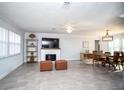 Open-concept living room with fireplace, dining area, ceiling fan, and neutral color palette at 11071 141St St, Largo, FL 33774