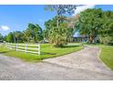 Charming house with a well-maintained lawn, mature trees, and a white picket fence at 11109 Winn Rd, Riverview, FL 33569