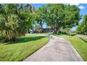 Exterior of charming house, showcasing its long driveway, expansive lawn, and mature trees at 11109 Winn Rd, Riverview, FL 33569