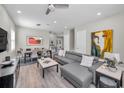Bright living room with sleek gray sectional, modern art, and an open concept layout at 112 W Sligh Ave, Tampa, FL 33604