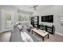Cozy living room with gray sectional, TV, entertainment center, and a view to the outside at 112 W Sligh Ave, Tampa, FL 33604