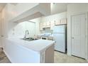 Bright kitchen features a peninsula with sink, white countertops, and appliances at 13025 Sanctuary Cove Dr # 301, Temple Terrace, FL 33637