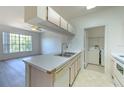 Bright kitchen with bar seating, stainless steel sink and view into the living room and laundry room at 13025 Sanctuary Cove Dr # 301, Temple Terrace, FL 33637