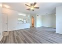 A spacious living room and dining area combo features modern gray floors and a ceiling fan at 13025 Sanctuary Cove Dr # 301, Temple Terrace, FL 33637