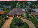 Aerial view of luxury home with lush landscaping, circular driveway, and a private residential neighborhood at 132 Giralda Ne Blvd, St Petersburg, FL 33704