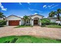 Charming single-Gathering home featuring a brick driveway, attached garage, and a well-manicured lawn at 132 Giralda Ne Blvd, St Petersburg, FL 33704