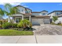 Attractive two-story home with a three-car garage and well-manicured lawn on a sunny day at 13859 Sharp Hawk Dr, Riverview, FL 33569