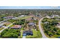 Aerial view of a community showcasing the single Gathering homes, lush greenery, and waterways at 14024 Wenzel Ave, Port Charlotte, FL 33981