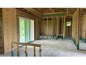 Unfinished living room with large glass doors, exposed wall studs, and a concrete floor at 14024 Wenzel Ave, Port Charlotte, FL 33981