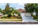 Inviting single-story home with a well-kept lawn, mature trees, and an attached garage with a double door at 14027 Bensbrook Dr, Spring Hill, FL 34609