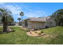 Side view of the home with a well-manicured lawn and landscaping beds, adding charm and character at 14181 Cornewall Ln, Spring Hill, FL 34609