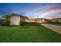 Well-manicured front yard of single-story home featuring a long driveway and lush green lawn at 14341 Passage Way, Seminole, FL 33776