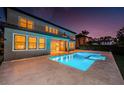 Backyard featuring a refreshing swimming pool and spa with outdoor living space, perfect for entertaining at twilight at 14806 Harry Colt Ct, Tampa, FL 33626