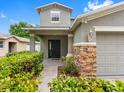 Close-up of the home's front entrance showing stacked stone details and verdant landscaping at 18320 Snowdonia Dr, Land O Lakes, FL 34638