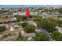 Aerial view of the home with a manicured lawn, mature trees and landscaping, conveniently located near the bay at 2048 Douglas Ave, Dunedin, FL 34698