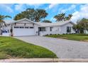 Charming single-story home with a well-manicured lawn, attached garage, and freshly painted white exterior at 2084 Massachusetts Ne Ave, St Petersburg, FL 33703