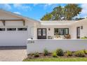 Charming single-story home with an attached garage, freshly painted white exterior, and manicured garden at 2084 Massachusetts Ne Ave, St Petersburg, FL 33703
