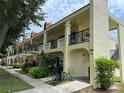 Condominium building featuring a bike rack and lush tropical landscaping at 2295 Mexican Way # 41, Clearwater, FL 33763