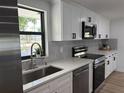 Kitchen features stainless steel appliances, granite countertops, undermount sink and white cabinets at 2551 12Th St, Englewood, FL 34224