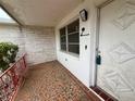 Inviting front porch featuring patterned tile flooring and a secure front door at 3035 Coldwell Dr, Holiday, FL 34691