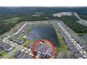 Aerial view of a neighborhood featuring homes surrounding a large lake and green spaces at 3063 Marine Grass Dr, Wimauma, FL 33598