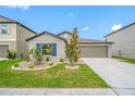 Well-maintained home featuring a beautifully landscaped front yard and a two-car garage at 31775 Sun Kettle Loop Loop, Wesley Chapel, FL 33545