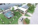 Waterfront home with screened pool, boat dock, lush landscaping, and circular driveway at 3654 Corsair Ct, New Port Richey, FL 34652