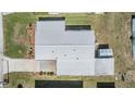 An aerial view shows the expansive roof and the surrounding landscape that features a driveway and grassy areas at 36750 Beth Ave, Zephyrhills, FL 33542