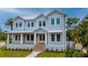 Beautiful two-story light blue home featuring a welcoming front porch and meticulously manicured lawn at 4311 W Sevilla St, Tampa, FL 33629
