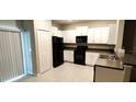 The kitchen features white cabinetry, black appliances, and countertop space at 4505 Globe Thistle Dr, Tampa, FL 33619