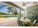 Covered patio with decorative furnishings, with views of the screened pool and golf course at 4508 Netherwood Dr, Tampa, FL 33624