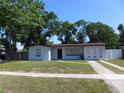 Charming single-story home boasts a well-maintained lawn, neutral paint, and a welcoming entryway at 4706 E Sligh Ave, Tampa, FL 33610