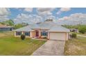 Beautiful single-story home with a metal roof, double door entry, and an attached two car garage at 5432 Queen Ave, Spring Hill, FL 34609