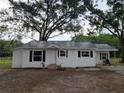 Well-maintained home featuring a metal roof, crisp white siding, and a covered side entrance at 5535 Peach Ave, Seffner, FL 33584
