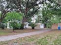 A cozy home and multiple outbuildings can be found surrounded by large trees and a driveway at 5535 Peach Ave, Seffner, FL 33584